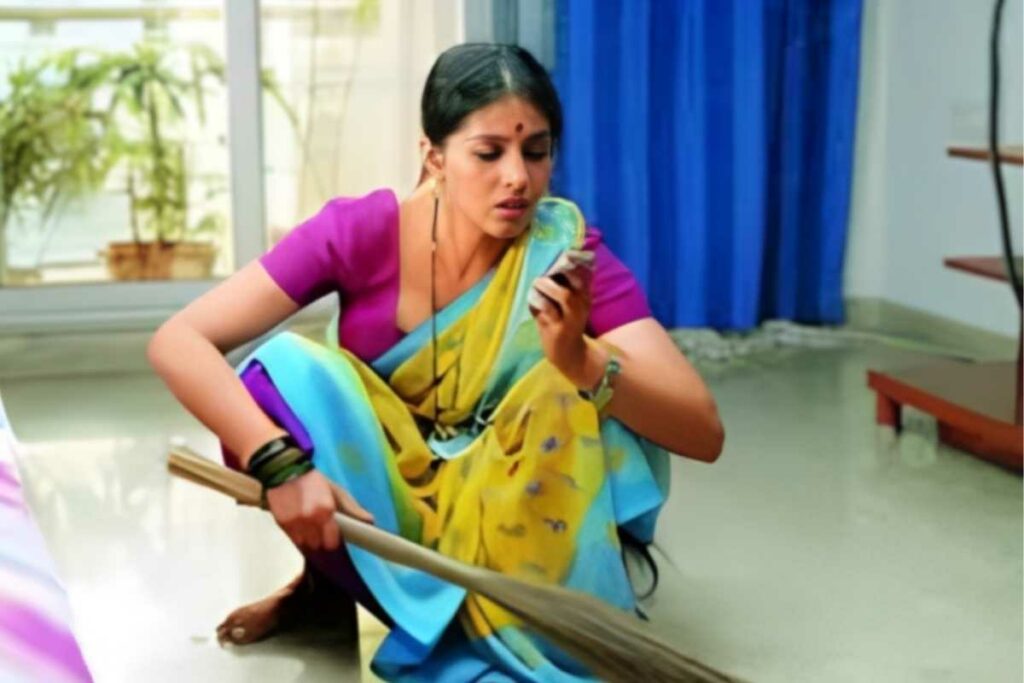 Indian Maid watching mobile while working in a home