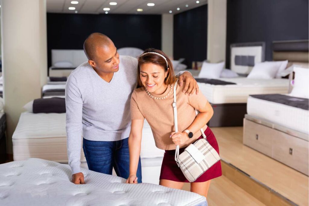 A couple shopping for a mattress in a store.