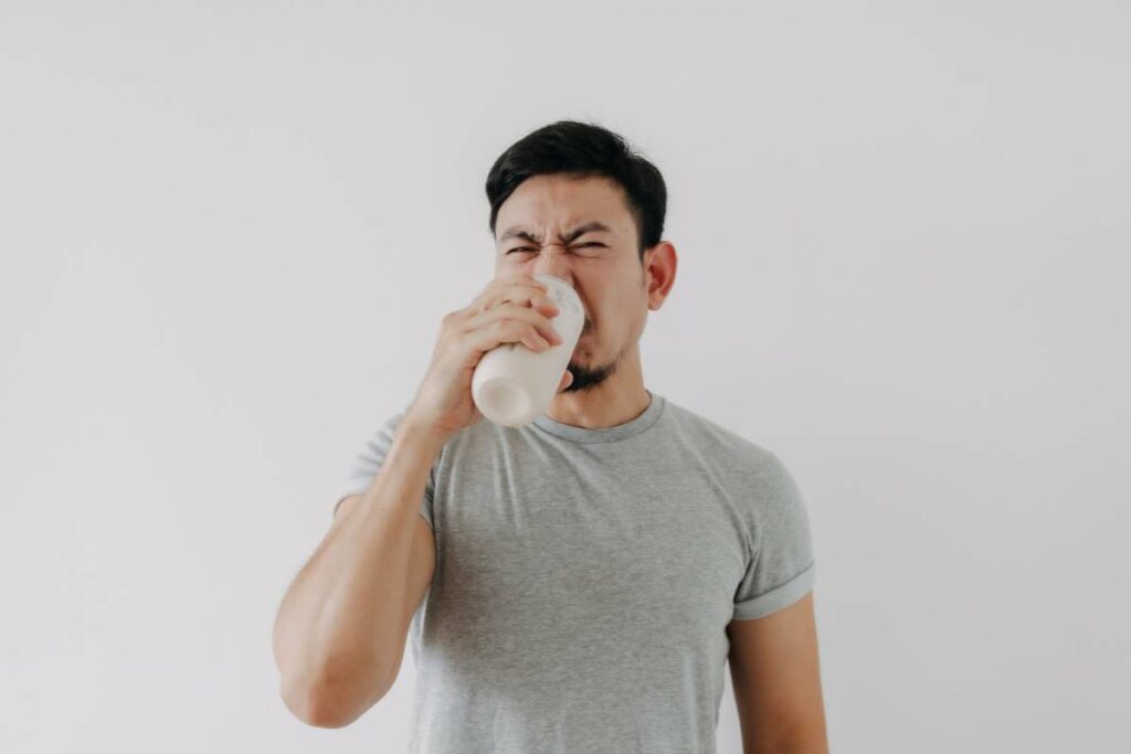 Man dealing with bad water taste, blowing nose and holding glass of water