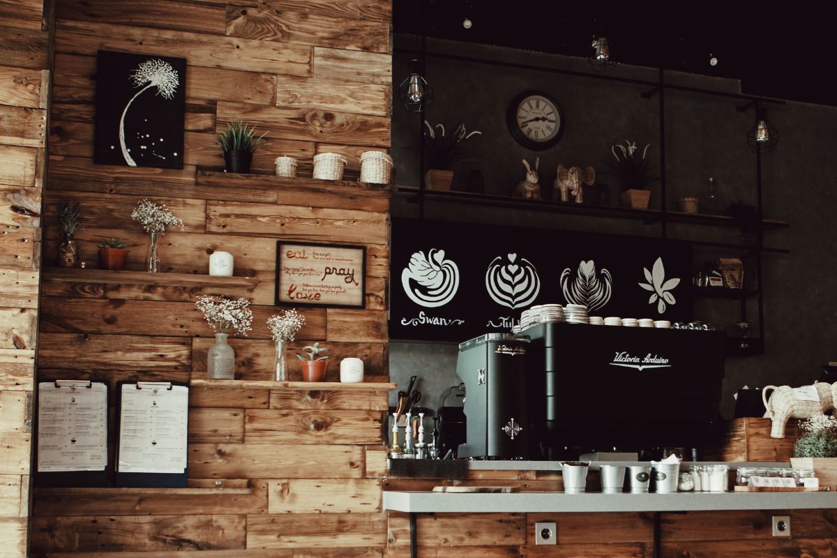 A charming coffee shop with wooden walls and shelves, including a Food Cafe counter