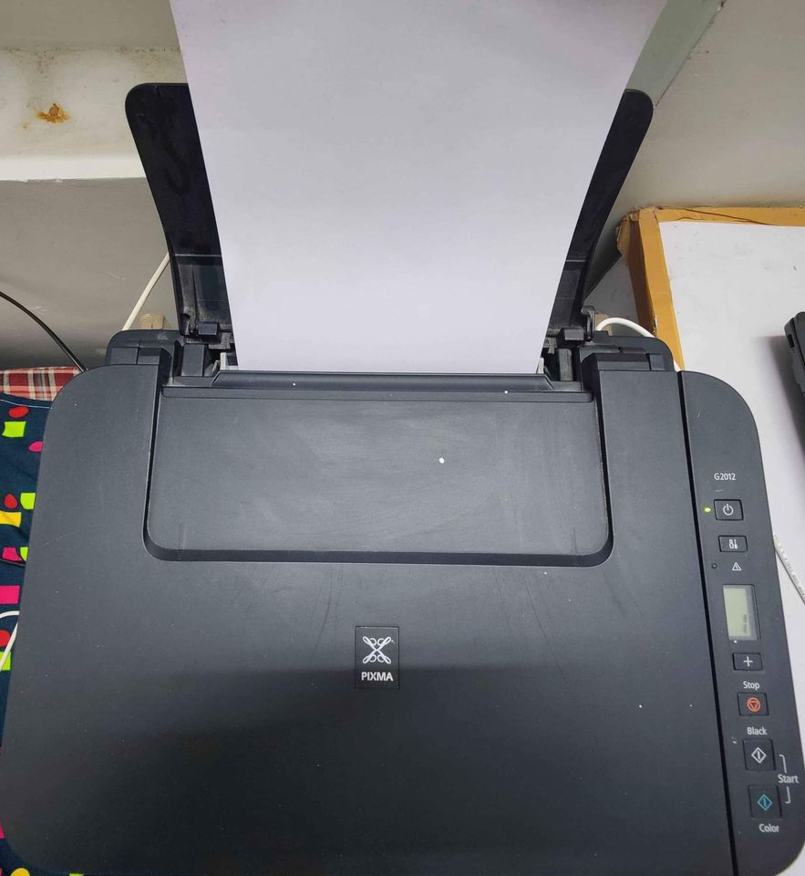 Feeding paper into Canon PIXMA MegaTank G2012 printer